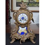 FRENCH STYLE GILT METAL MANTEL CLOCK WITH HANDPAINTED PORCELAIN DIAL AND PANEL,