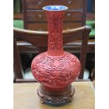 HEAVILY CARVED ORIENTAL CINNABAR STYLE VASE WITH CLOISONNE INTERIOR AND BASE ON CARVED PIERCEWORK