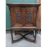 HEAVILY CARVED ANTIQUE OAK TWO DOOR CABINET WITH BARLEY TWIST SUPPORTS AND FRUIT AND VINE