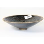 A Chinese black glazed porcelain bowl with relief decoration of a dragon, Dia 19.5cm