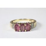 A 9ct yellow gold ring set with 3 pink sapphires and diamond shoulders (O)