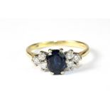 An 18ct yellow gold ring set with a sapphire and diamonds. Size N