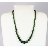 A graduated strand of spinach jade beads