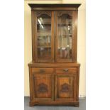 An Edwardian carved mahogany bookcase on cabinet, W 105cm, H 210cm