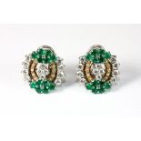 A superb pair of white and yellow metal (tested 18ct gold) earrings set with emeralds and