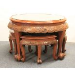 An oriental carved hardwood table with a glass top and four carved stools, Dia 80cm, H 53cm