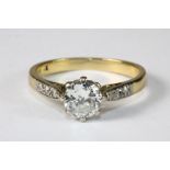 An 18ct yellow gold ring set with a solitaire diamond approx. 0.9ct with diamond set shoulders. Size