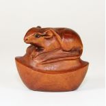 A carved and signed fruit wood netsuke of a mouse with black onyx eyes on a boat "cash"
