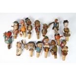 A collection of Black Forest carved wooden articulated wine bottle stoppers