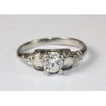 A lovely platinum and diamond Art Deco style solitaire ring with diamond set shoulders (K)