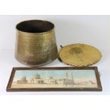 An Egyptian engraved brass spittoon, framed print and a 1943 camel skin wall hanging signed by