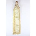 A small articulated bisque porcelain baby doll (10cm) with long Christening style robe