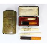 A Japanese gilt decorated horn cigarette box and 5 mixed cigarette holders