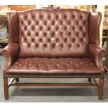 A vintage button backed leather two seater office/hotel reception settee, W. 140cm.