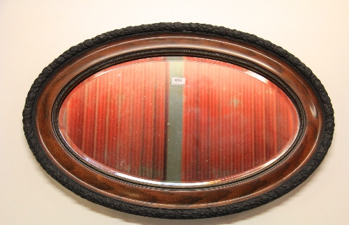A framed oval bevelled mirror, W. 85cm.