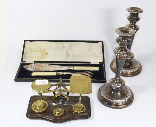 A pair of silver plated candle sticks, a Post Office scale and fish serving set.