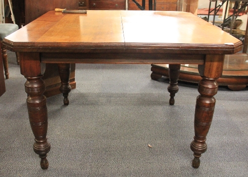 A Victorian mahogany wind out dining table with single additional leaf.