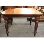 A Victorian mahogany wind out dining table with single additional leaf.