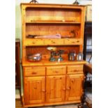 A contemporary pine tall dresser, having