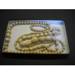 A graduated string of oval ivory beads,
