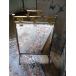 An Edwardian brass fire screen with mirrored plate and carrying handle.