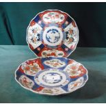 A near pair of Imari dishes, typically decorated with segmented borders, 21cm diameter.