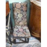 A nursing chair with needlework back and seat on oak legs.