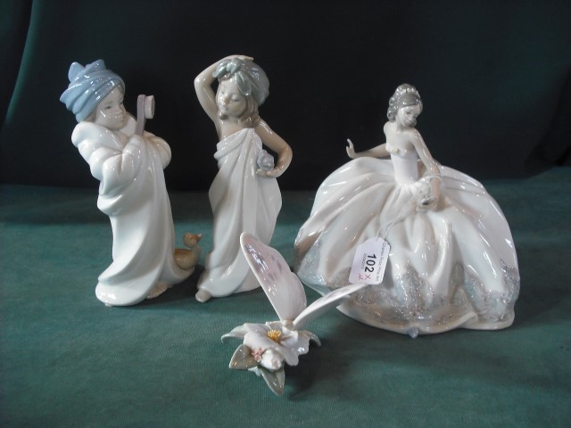 A Lladro figure of a seated ballerina and three other Lladro figures.