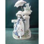 A Lladro figure, modelled as a young girl holding an umbrella and standing by a plinth, 33cm high.