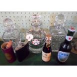 Three glass spirit decanters with stoppers, a leather an chrome hip flask,