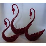 A set of graduated Whitefriars style swan dishes, in deep red, 16 to 26cm.