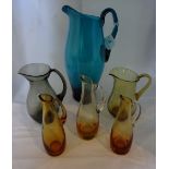 A collection of six Whitefriars-style jugs, various colours and sizes.