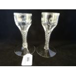 A pair of wine glasses, the engraved bowls with lambrequin borders on air-drawn stems, circa 1760,