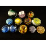 A quantity of twelve small glass paperweights, to include an example by Caithness and Murano.