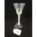 A wine glass with moulded bowl on a stem with central stand within a double opaque strand,