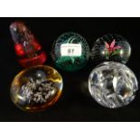 Three Caithness glass paperweights, to include: 'Flower in the Rain', 'Cauldron Emerald' and 'Nova',