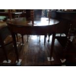 A mahogany circular occasional table on four tapering supports.