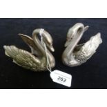 A pair of silver table salts fashioned as swans, having ruby coloured eyes, by Elkington & Co.