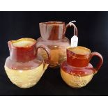 Three Doulton Lambeth salt glazed stoneware Harvest jugs, each with typical sprig decoration, the