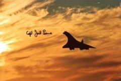 Concorde: 8x12 inch photo, a view of Concorde silhouetted against an orange sunset, signed by former