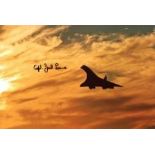 Concorde: 8x12 inch photo, a view of Concorde silhouetted against an orange sunset, signed by former