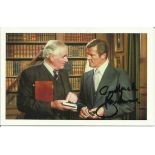 Roger Moore signed 6x4 James Bond postcard. Seen here alongside Desmond Llewelyn. Good condition