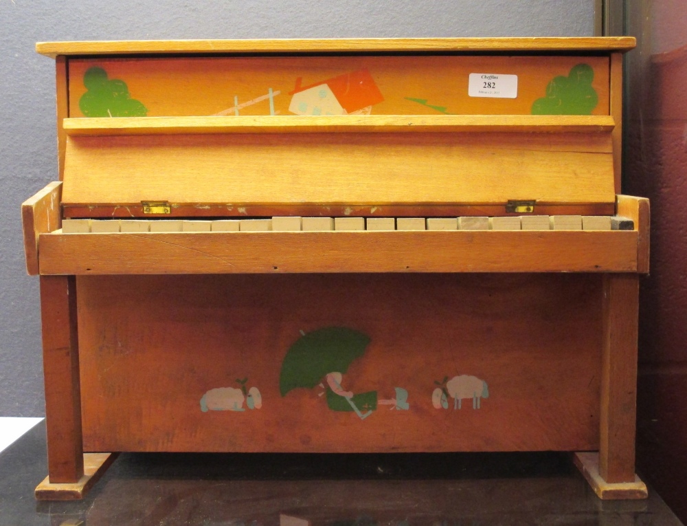 A toy 'piano' with painted decoration to the front