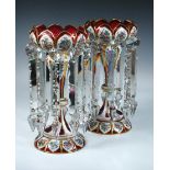 A pair of mid 19th century Bohemian cranberry glass lustres, the bodies overlaid in white with