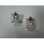 A pair of Italian 18ct white gold and blue topaz earclips, each with a square cut pale blue topaz in