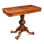 A mid Victorian figured walnut fold over tea table, on pedestal base and four scroll carved legs