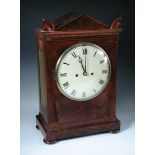 A Regency mahogany bracket clock, the Egyptian style case with arched pediment and enamel dial, twin