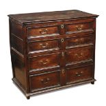A Charles II oak chest of drawers, four long drawers with swan neck brass handles, on stile legs