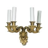 A pair of ormolu four branch wall lights, each leaf moulded backplate issuing four foliate candle