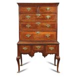 An oak chest on stand, mid 18th century, crossbanded decoration on cabriole legs with shell carved